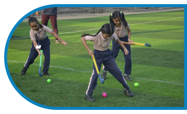 Girls playing hocky on ground at CBSE school