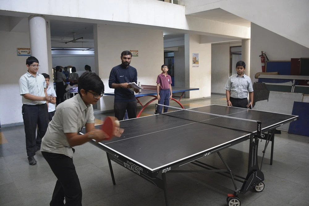 A students play tabble tennis at anand niketan school